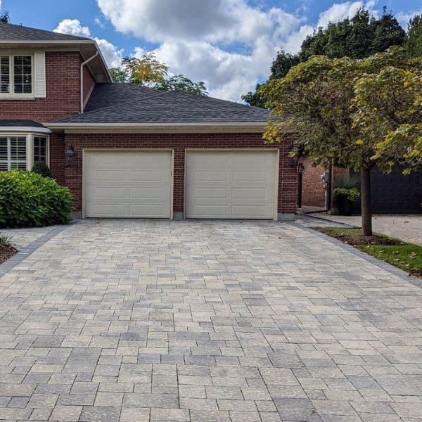 Permeable paver driveway running up to a modern home